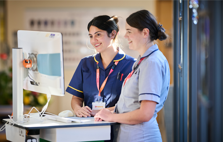 Nurses standing at a mobile computer smiling