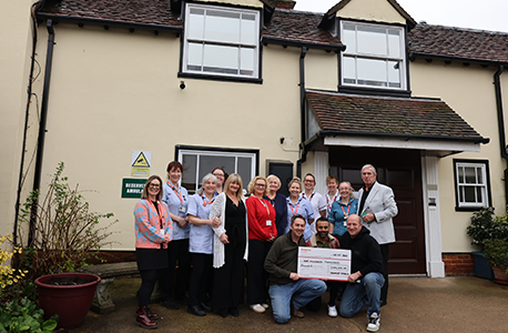St Helena Hospice staff presented with 100k cheque from cyclists outside the hospice