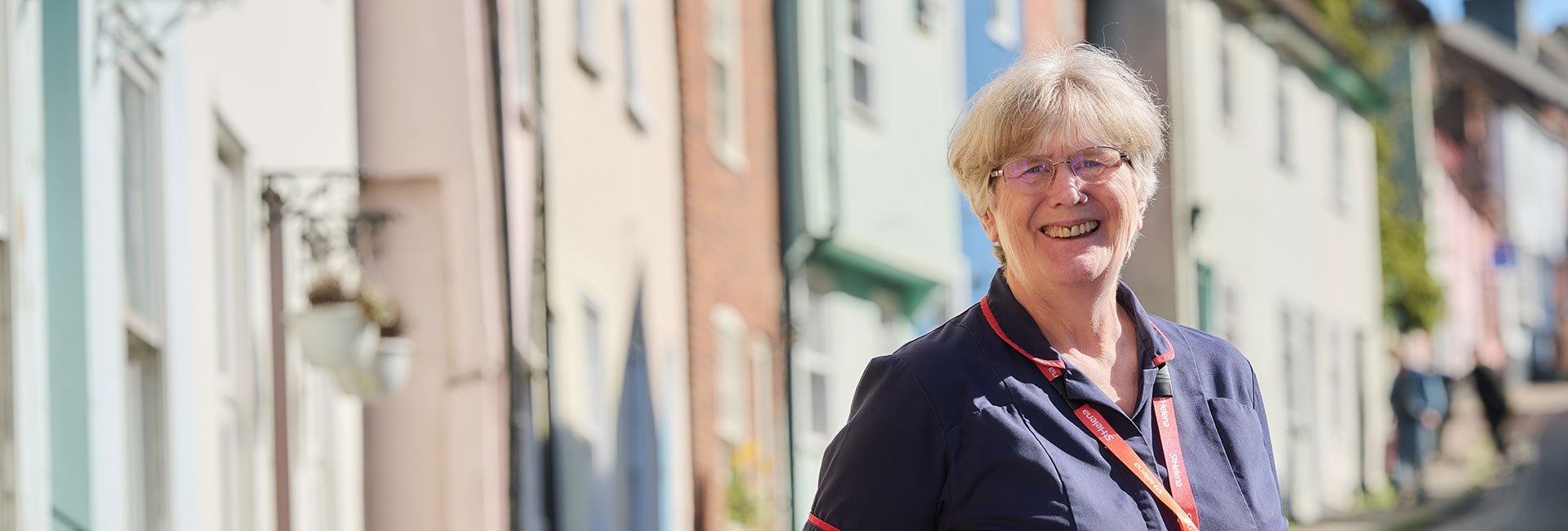 A St Helena nurse smiling in front of some colourful houses in Colchester