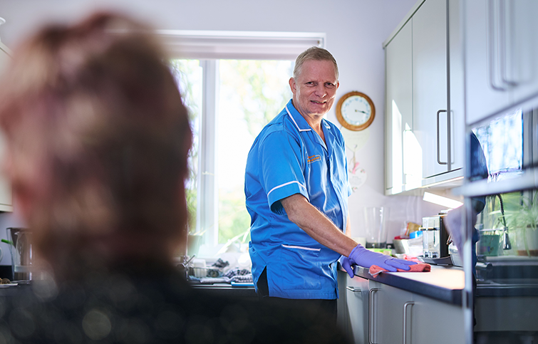 A St Helena Care & Support Assistant cleaning a customers kitchen